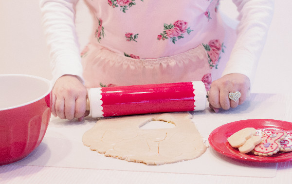 Small hands baking heart shaped cookies